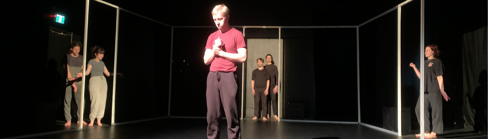 five actors stand in door frames on stage with one actor in foreground from scene in The Unbounded production